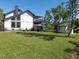 The home's backyard view shows a lush lawn, modern home with dual decks, and waterside access at 1471 Arcadia Ave, Sarasota, FL 34232