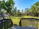 Expansive backyard view from deck, showcasing lush greenery and mature trees under a clear blue sky at 1471 Arcadia Ave, Sarasota, FL 34232