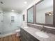 Modern bathroom with double sink vanity, granite countertop, and a tiled glass-enclosed shower at 1471 Arcadia Ave, Sarasota, FL 34232