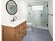 Updated bathroom featuring a glass shower, modern fixtures, and a stylish vanity with a round mirror at 1471 Arcadia Ave, Sarasota, FL 34232