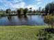 Scenic pond view featuring a serene body of water surrounded by lush landscaping and clear skies at 1471 Arcadia Ave, Sarasota, FL 34232