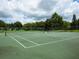 Outdoor tennis court with green surface, net, and ample space for play, perfect for sports enthusiasts at 1471 Arcadia Ave, Sarasota, FL 34232