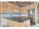 Unfinished kitchen with wood cabinets, island with granite counters, tile floors, and stainless microwave at 15 Seaside Ct, Holmes Beach, FL 34217