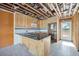 Kitchen with wooden cabinets, granite counters, stainless microwave, and tile backsplash, ready for remodeling at 15 Seaside Ct, Holmes Beach, FL 34217