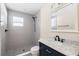 Modern bathroom with grey tiled shower, patterned tile floor, and navy blue vanity with white countertop at 1739 16Th S Ave, St Petersburg, FL 33712