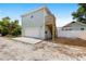 Back of home with light green painted siding, a 2 car garage and stair case at 1739 16Th S Ave, St Petersburg, FL 33712