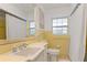 Classic bathroom featuring vanity, mirror, toilet, and shower with yellow tiling, and natural light at 1870 Jasmine Dr, Sarasota, FL 34239