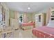 Charming bedroom featuring two twin beds with white frames, pink bedding, and natural light from the window at 1870 Jasmine Dr, Sarasota, FL 34239