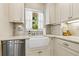 Updated kitchen with white cabinets, granite countertops, stainless steel appliances, and a farm sink at 1870 Jasmine Dr, Sarasota, FL 34239