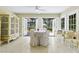 Bright sunroom features tiled flooring, decorative cabinet, and opens up to a view of the backyard at 1870 Jasmine Dr, Sarasota, FL 34239