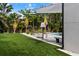 Beautiful backyard oasis featuring lush landscaping, an artificial lawn, inviting pool, and ample space for relaxing at 2305 Pine Ter, Sarasota, FL 34231
