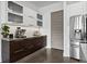 Stylish wet bar with frosted upper cabinets, espresso machines and stainless steel refrigerator at 2305 Pine Ter, Sarasota, FL 34231