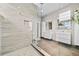 Bathroom with a glass shower, white cabinets, and dark tile at 2305 Pine Ter, Sarasota, FL 34231