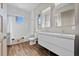 Clean bathroom featuring subway tiles, a modern double sink vanity, and a window providing natural light at 2305 Pine Ter, Sarasota, FL 34231