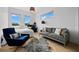 Sunlit bedroom featuring sleek hardwood floors, a plush gray sofa, and an inviting accent chair at 2305 Pine Ter, Sarasota, FL 34231