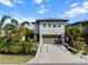 Two-story home featuring a modern exterior, a spacious driveway, and lush landscaping on a sunny day at 2305 Pine Ter, Sarasota, FL 34231