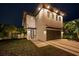 Stunning modern two-story home with a sleek design, manicured lawn, and inviting curb appeal at night at 2305 Pine Ter, Sarasota, FL 34231