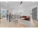 Hallway with hardwood floors, metal banister, a leather couch, and a gray door at 2305 Pine Ter, Sarasota, FL 34231