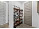 Open shelving storage area with decorative items, bottles and jars; next to a gray paneled door at 2305 Pine Ter, Sarasota, FL 34231