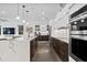 Stylish kitchen with a large island, stainless steel appliances, and sleek white cabinets at 2305 Pine Ter, Sarasota, FL 34231
