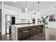 Modern kitchen island with barstool seating, white cabinetry, and stainless steel appliances at 2305 Pine Ter, Sarasota, FL 34231
