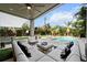 Inviting outdoor living space featuring comfortable seating, ceiling fan, and view of pool surrounded by lush landscaping at 2305 Pine Ter, Sarasota, FL 34231