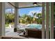 Covered patio with comfortable seating and view of pool area and lush landscaping at 2305 Pine Ter, Sarasota, FL 34231