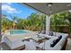 Covered patio with ample seating overlooking a swimming pool and tropical landscaping at 2305 Pine Ter, Sarasota, FL 34231