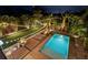 Gorgeous backyard with a sparkling pool, lounge chairs, and lush tropical landscaping with festive string lights at 2305 Pine Ter, Sarasota, FL 34231