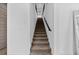 Modern staircase with carpeted steps and minimalist black railing against crisp white walls at 2305 Pine Ter, Sarasota, FL 34231