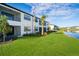 Exterior view of home backing up to pond with lush landscaping and palms at 23445 Collina Way # 10103, Port Charlotte, FL 33980
