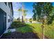 Exterior view of home backing up to pond with lush landscaping and palms at 23445 Collina Way # 10103, Port Charlotte, FL 33980