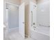 Bathroom features a white tiled shower-tub and accessibility bars and doorway at 23445 Collina Way # 10103, Port Charlotte, FL 33980