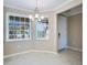 Light-filled dining room featuring tile floors, a modern chandelier, and bright windows with blinds at 23445 Collina Way # 10103, Port Charlotte, FL 33980