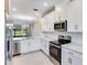 Modern kitchen featuring stainless steel appliances, white cabinets, and sleek countertops at 23445 Collina Way # 10103, Port Charlotte, FL 33980