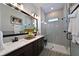 Modern bathroom with dual sinks, marble countertop, and a glass-enclosed shower with gray subway tile surround at 2401 Ezzell Ct, Sarasota, FL 34237