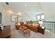 Upstairs living room features a brown leather sectional sofa, wood accent tables and carpet flooring at 2401 Ezzell Ct, Sarasota, FL 34237