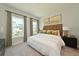 Well-lit main bedroom featuring neutral walls, carpet flooring, and large windows with charming curtains at 2401 Ezzell Ct, Sarasota, FL 34237