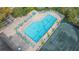 Aerial view of a community pool and tennis courts with ample deck space and lounge chairs at 3016 Highlands Bridge Rd, Sarasota, FL 34235