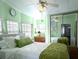 Bright bedroom featuring fresh green walls, plush bedding, and mirrored closet doors at 3333 26Th E Ave # 1220, Bradenton, FL 34208