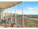 Spacious screened balcony with seating area overlooking serene water and lush landscape views at 3603 N Point Rd # 702, Osprey, FL 34229