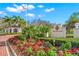 Welcome to The Oaks Club sign, surrounded by colorful flowers and lush landscaping at 3603 N Point Rd # 702, Osprey, FL 34229