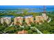 Beautiful view of the condo buildings near the water, surrounded by lush greenery at 3603 N Point Rd # 702, Osprey, FL 34229