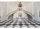 Grand foyer featuring a dual staircase, black-and-white checkered flooring, and an ornate chandelier at 3603 N Point Rd # 702, Osprey, FL 34229