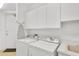 Functional laundry room with washer, dryer, ample cabinet space, and utility sink at 3603 N Point Rd # 702, Osprey, FL 34229