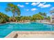 Inviting community swimming pool with lounge chairs, lush landscaping, and shaded cabana at 3603 N Point Rd # 702, Osprey, FL 34229
