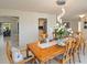 Spacious dining room with a modern light fixture, beautiful wood table, and tile floors at 3876 Torrey Pines Blvd, Sarasota, FL 34238
