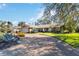 Charming single-story home features mature landscaping, a tile roof, and a long driveway at 3876 Torrey Pines Blvd, Sarasota, FL 34238