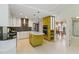 Bright, white kitchen with a yellow-green island, tiled backsplash, and stainless steel appliances at 3876 Torrey Pines Blvd, Sarasota, FL 34238