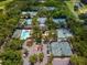 Aerial view of a community center featuring a pool, tennis courts, and parking area at 3982 Chatsworth Greene # 37, Sarasota, FL 34235